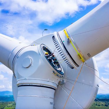 Zoom-in of workers installing wind turbine blades