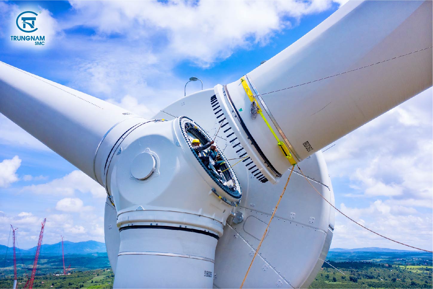 Zoom-in of workers installing wind turbine blades